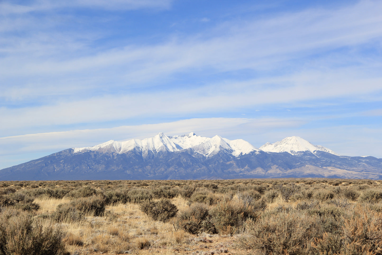 Experience the allure of vast open spaces framed by towering peaks