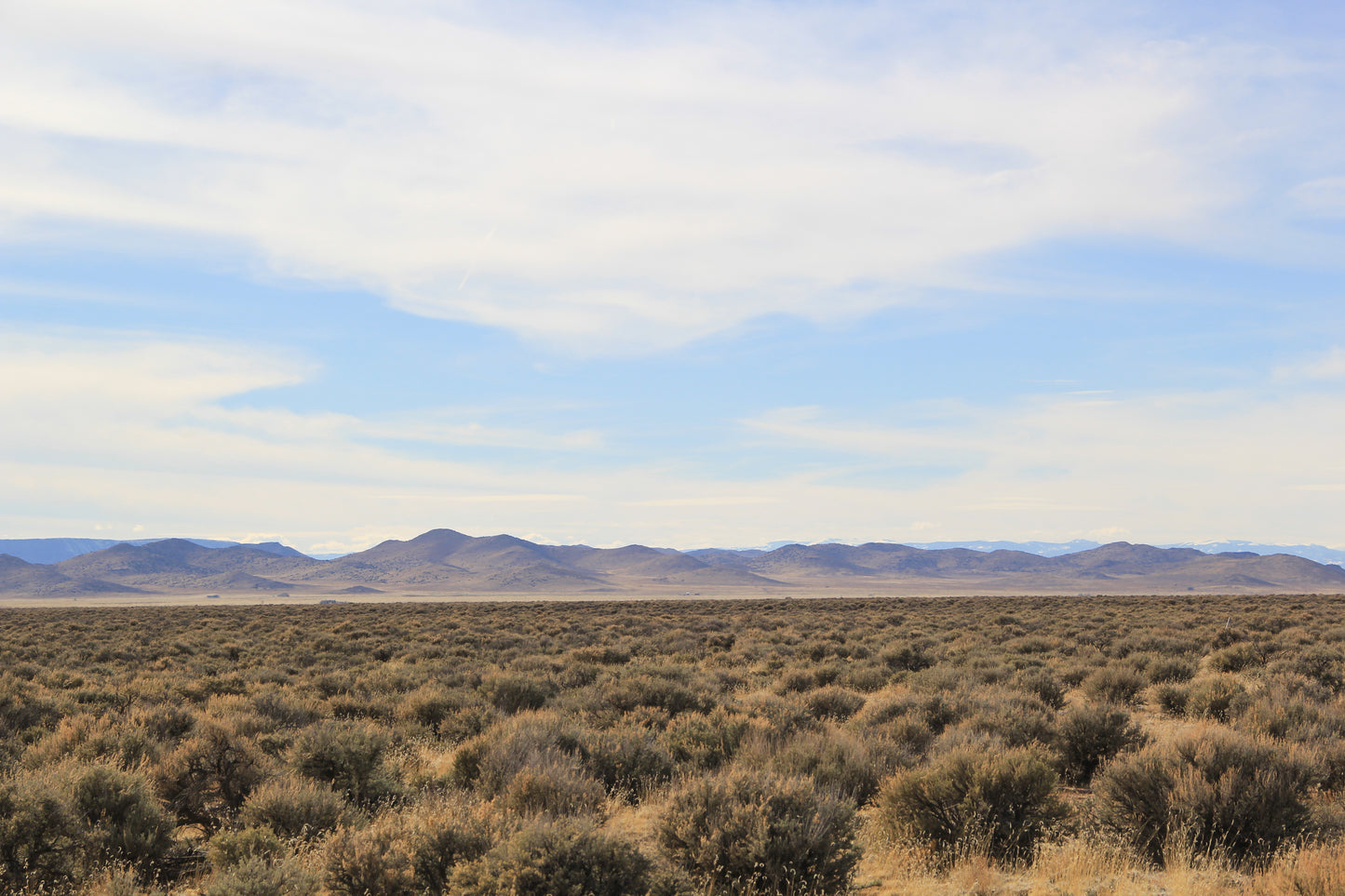 Experience the allure of vast open spaces framed by towering peaks